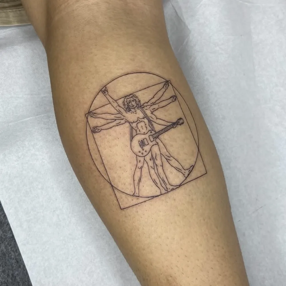Tatuaje fine line del hombre de Vitruvio con guitarra eléctrica en la pantorrilla, Madrid